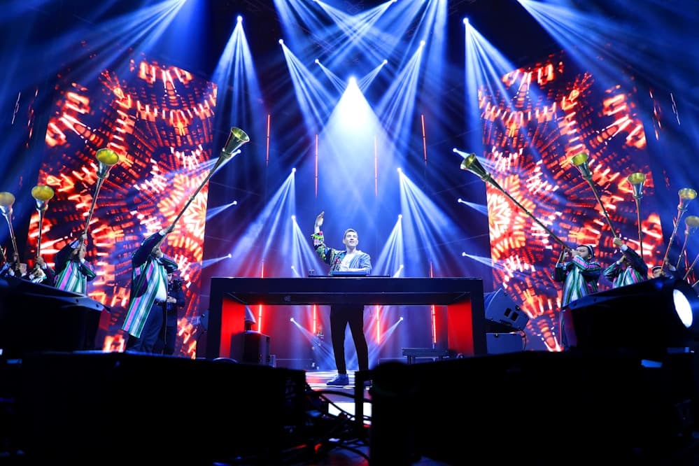 Wide shot of a concert venue filled with lights and fans