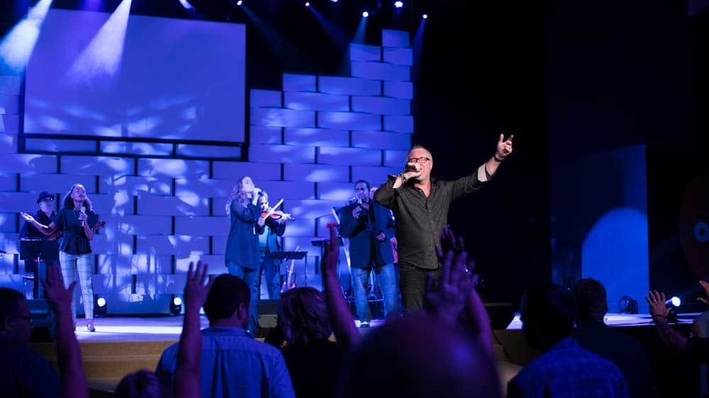 Crowd at a concert raising hands and enjoying the music