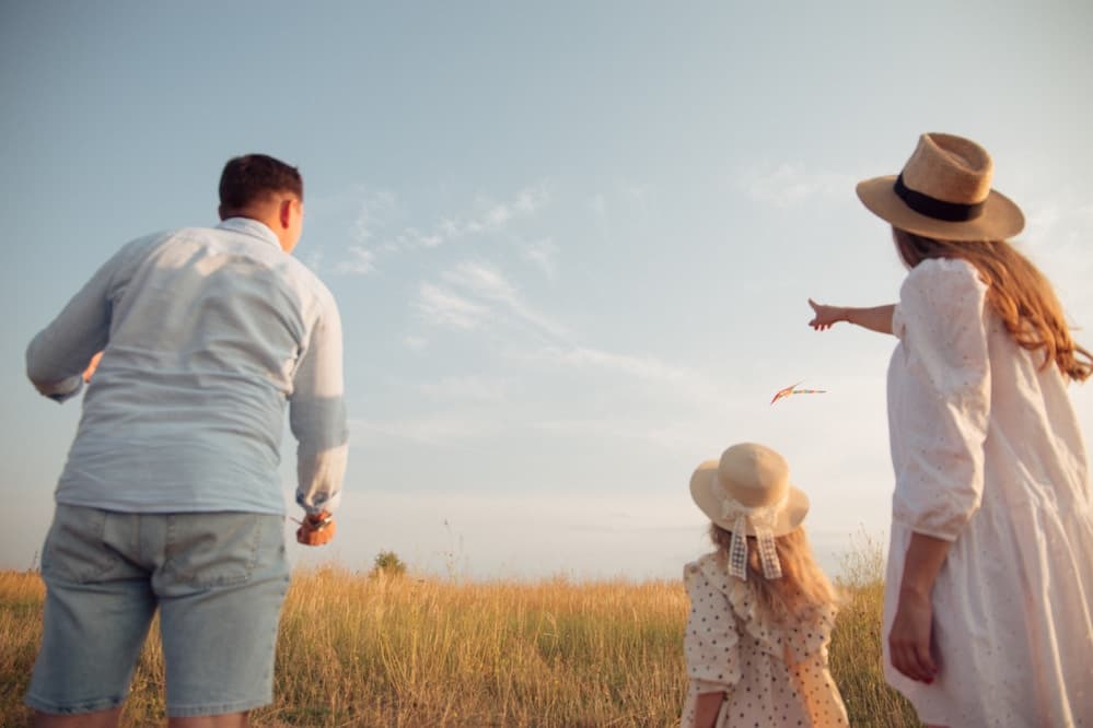 Parents holding hands with their children in a park