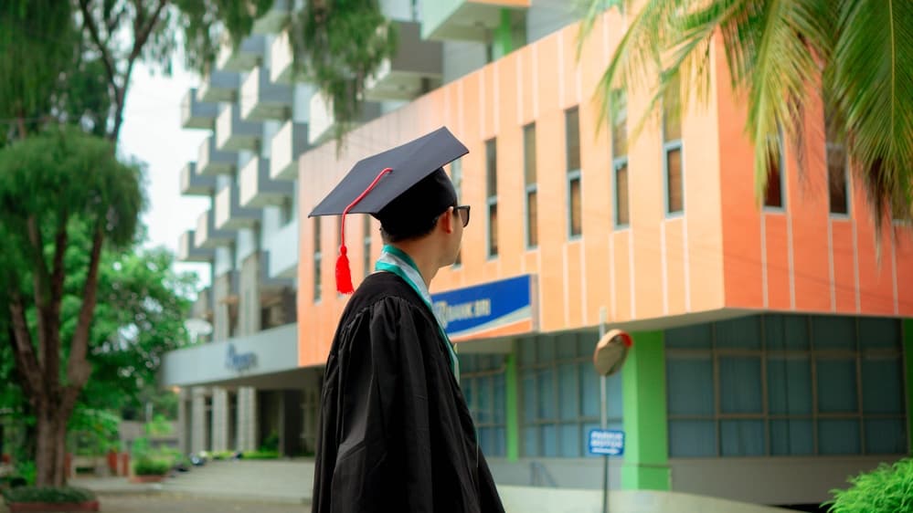 Graduate holding their degree certificate and smiling