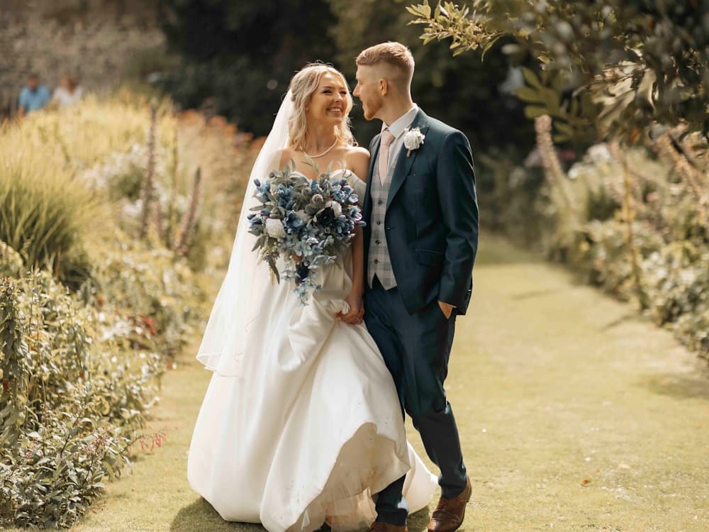 Bride and groom posing in lush greenery